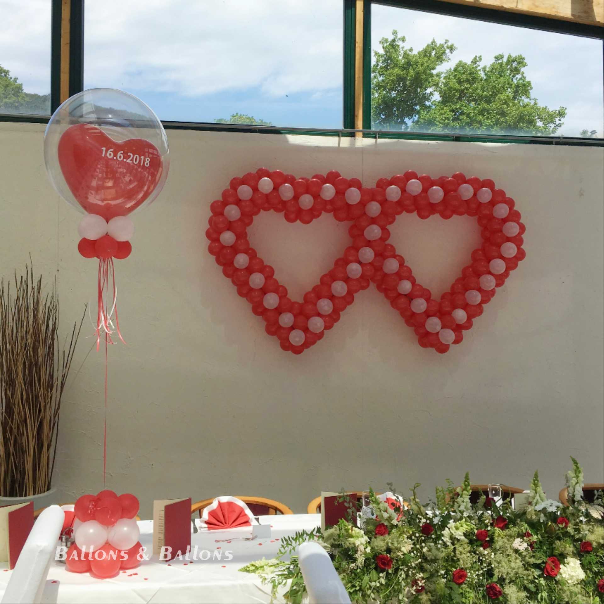 Ein Herzballon mit Blumen auf einem Tisch.
