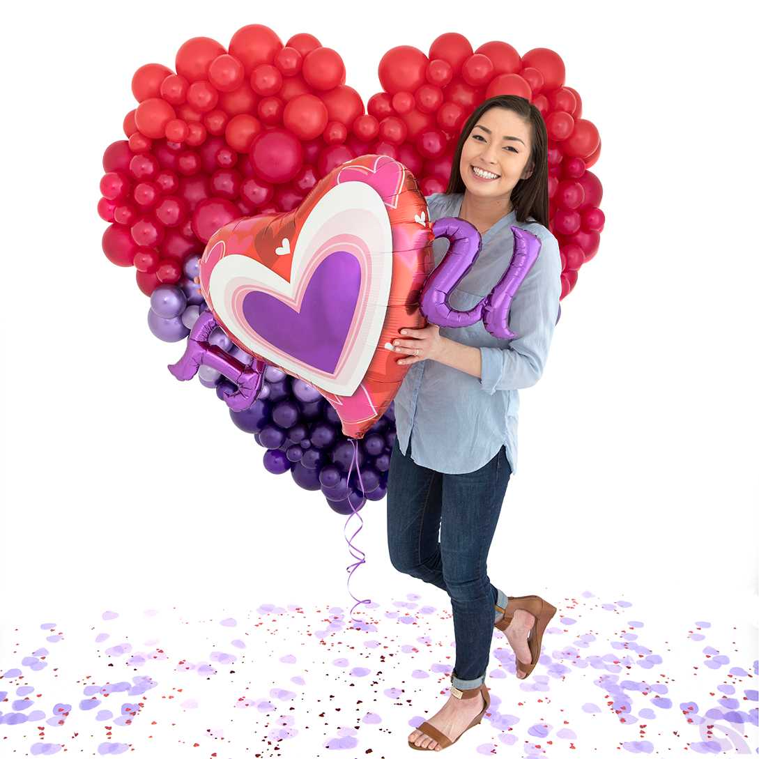 Ein Mädchen hält einen großen Herzballon.