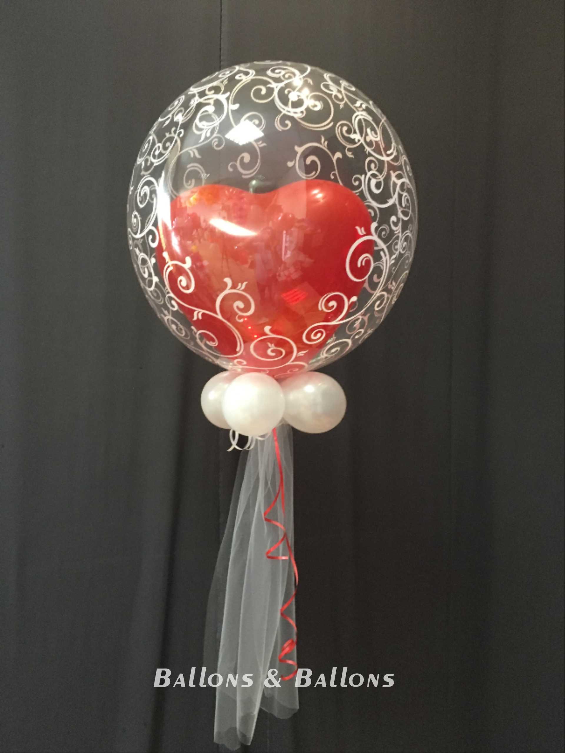 Ein Ballon mit roten Herzen in einem durchsichtigen Ballon.