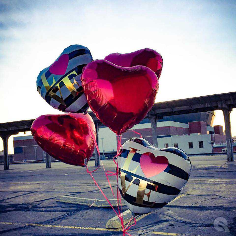 Herzballons auf einem Auto in einem Parkplatz.
