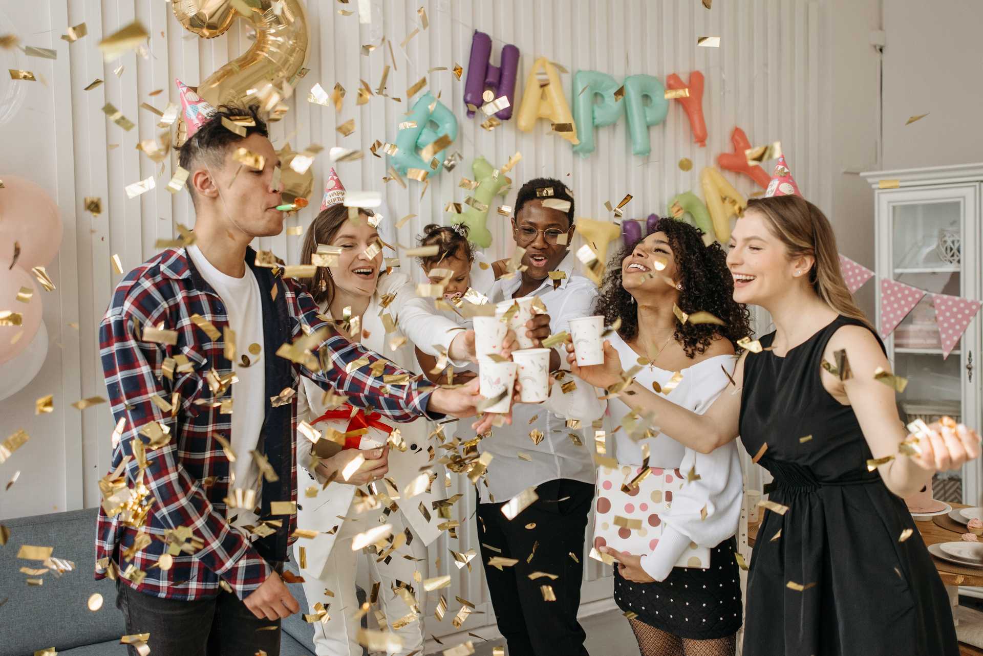 Eine Gruppe von Menschen feiert ihren Geburtstag mit Kuchen und Konfetti.