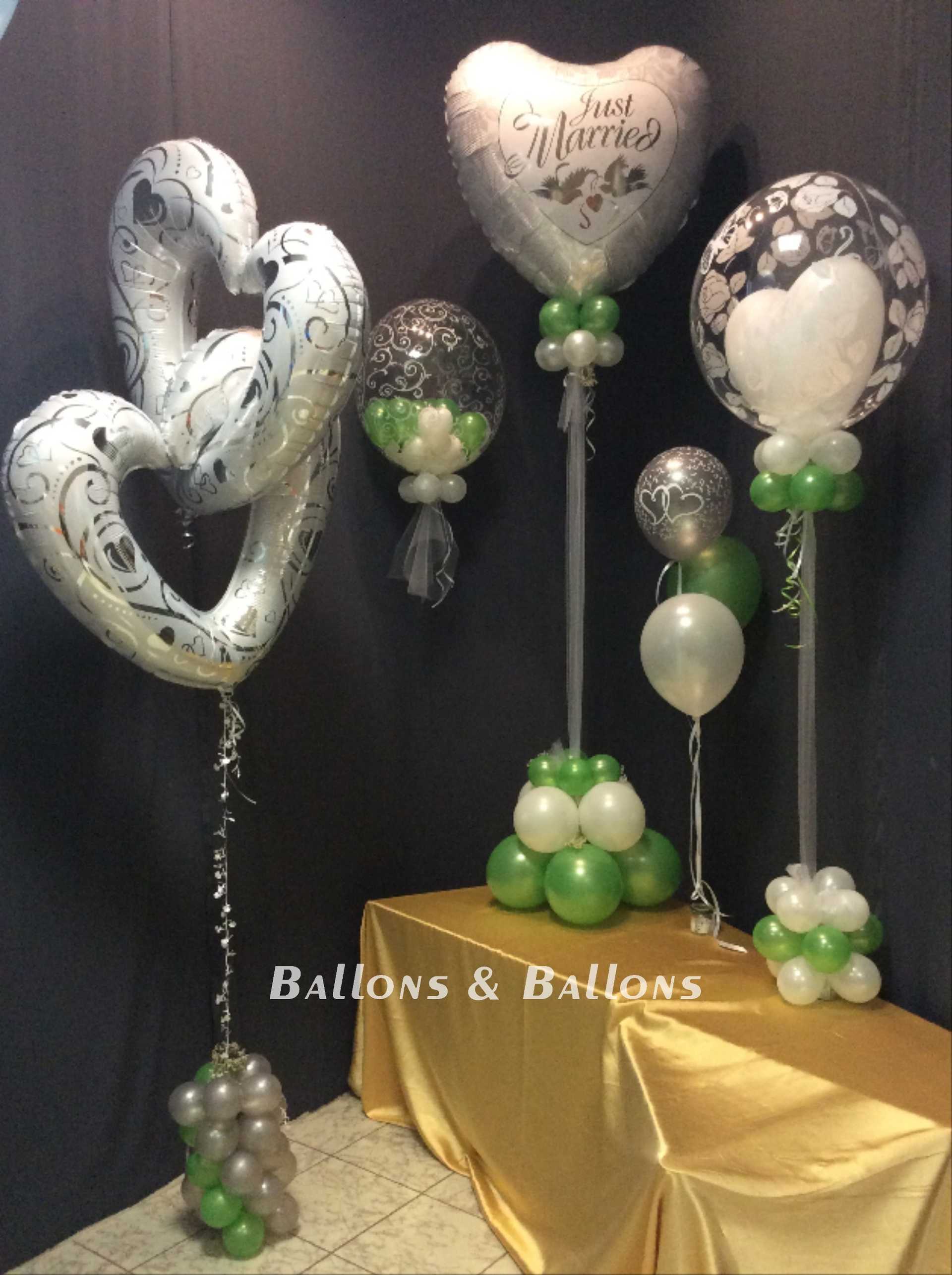 Ballondekoration und Tisch mit weißen und grünen Luftballons.