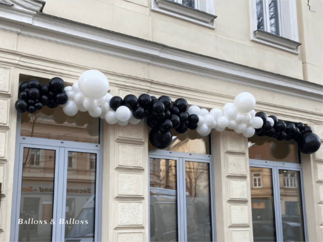 Ein schwarzer und weißer Ballonbogen über einem Geschäft in Wien