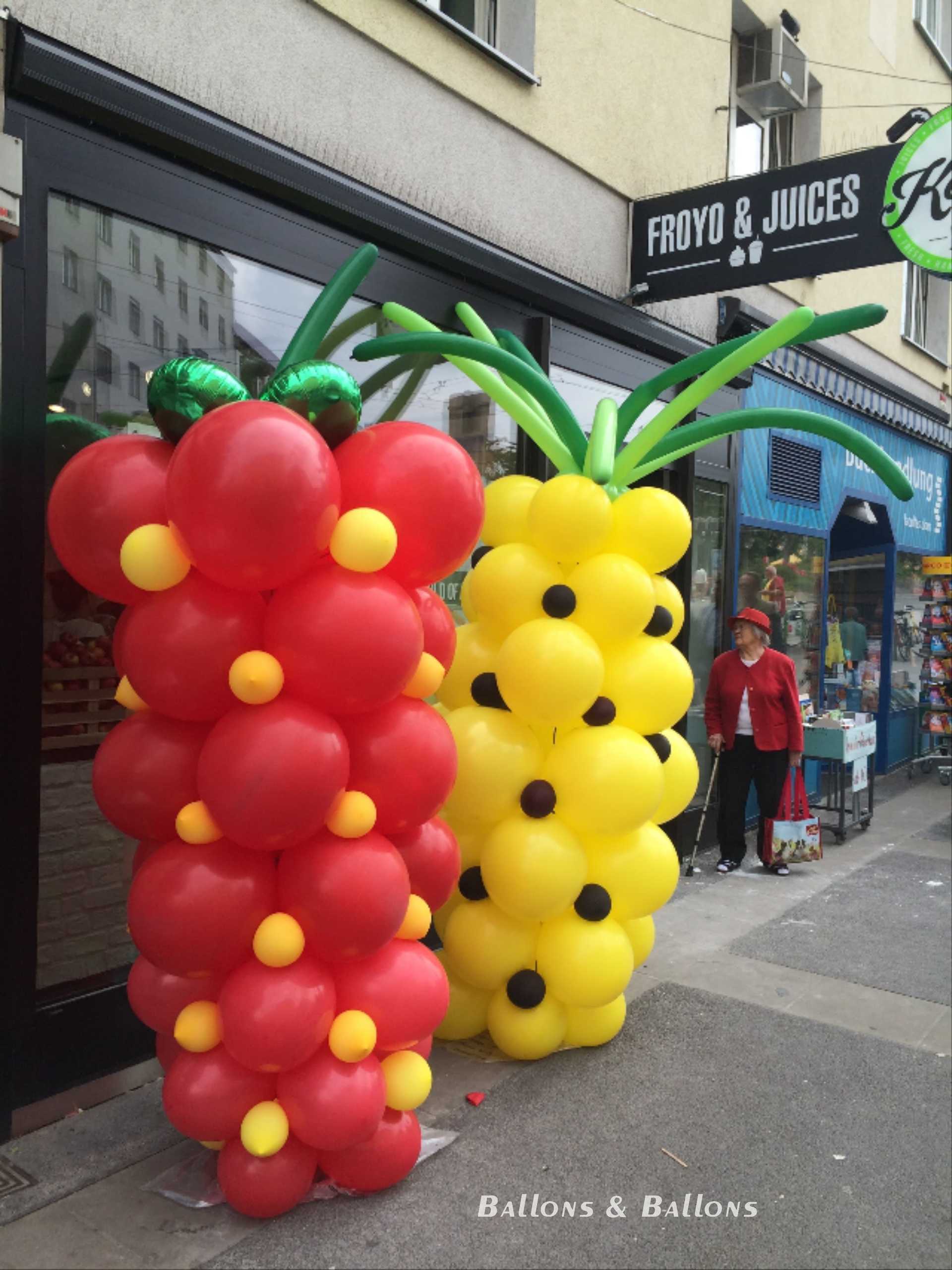 Ein Stand vor einem Geschäft mit roten und gelben Ballons in Wien.