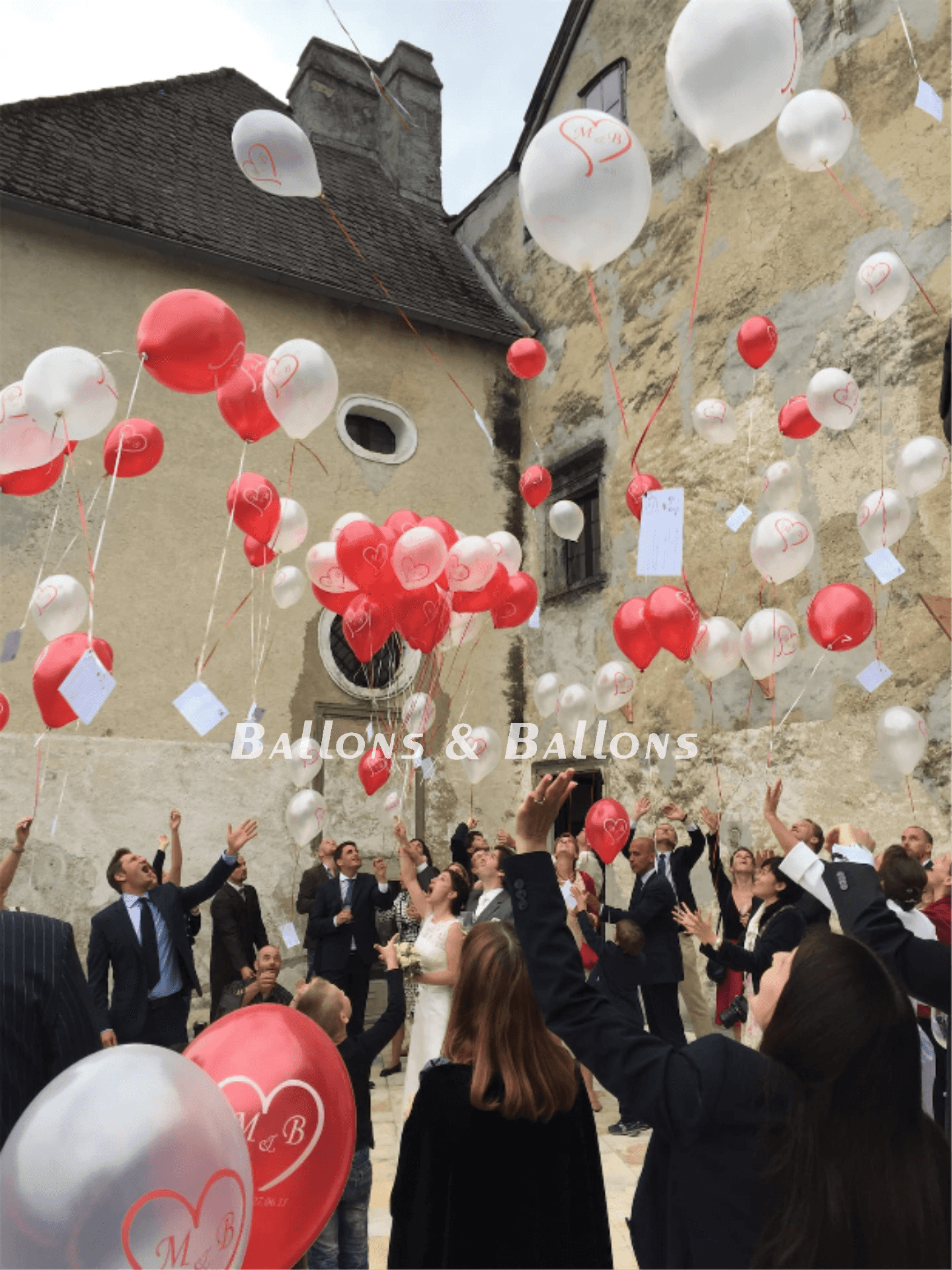 Eine Gruppe von Menschen feiert ihre Hochzeit und gibt Ballons aus.