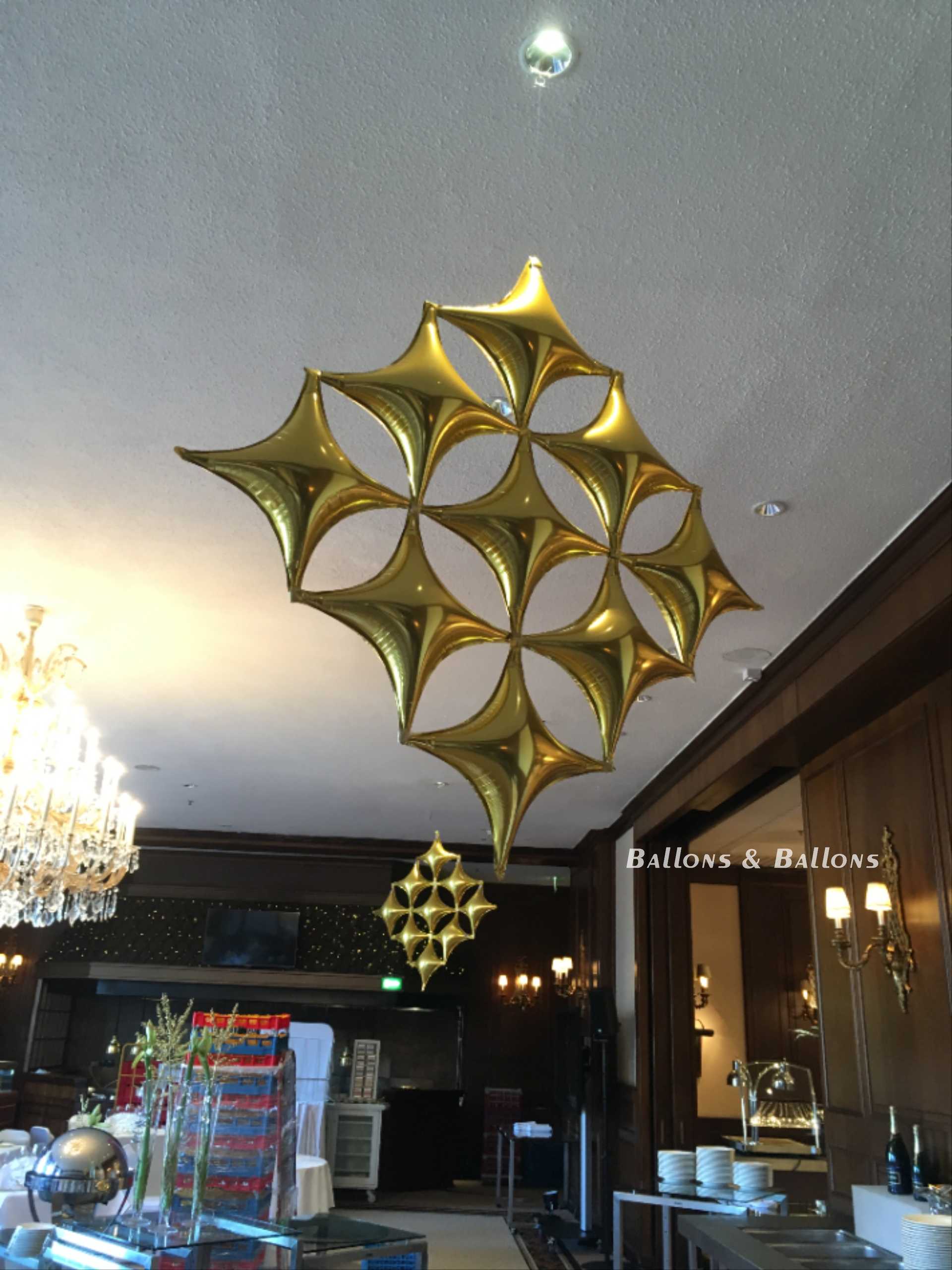 Ein luxuriös dekorierter Raum mit vielen Kronleuchtern und goldenen Sternen in einem Restaurant in Wien.