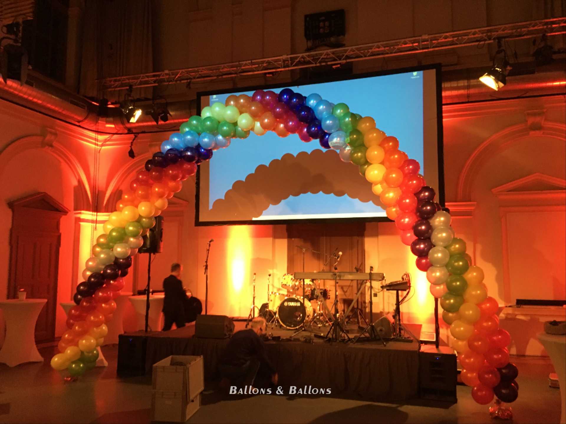 Eine Bühne mit einem Ballonbogen und einer Band, die in Wien spielt