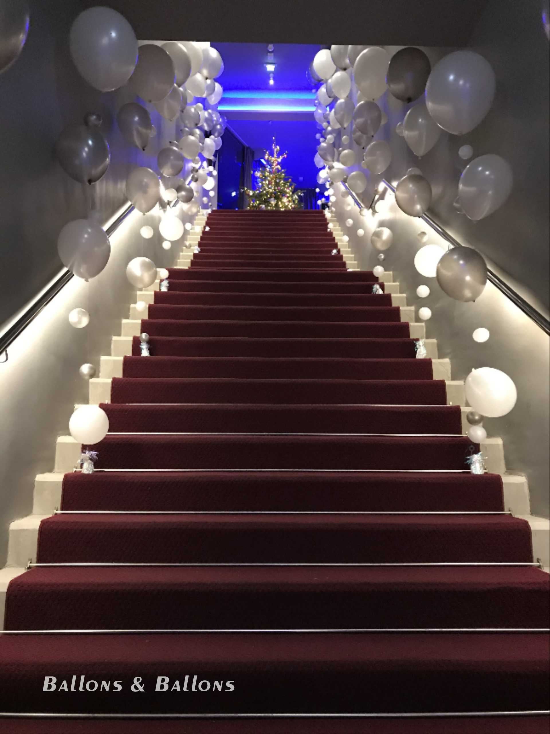 Eine Treppe mit weißen Ballons und Weihnachtslichtern in Wien.