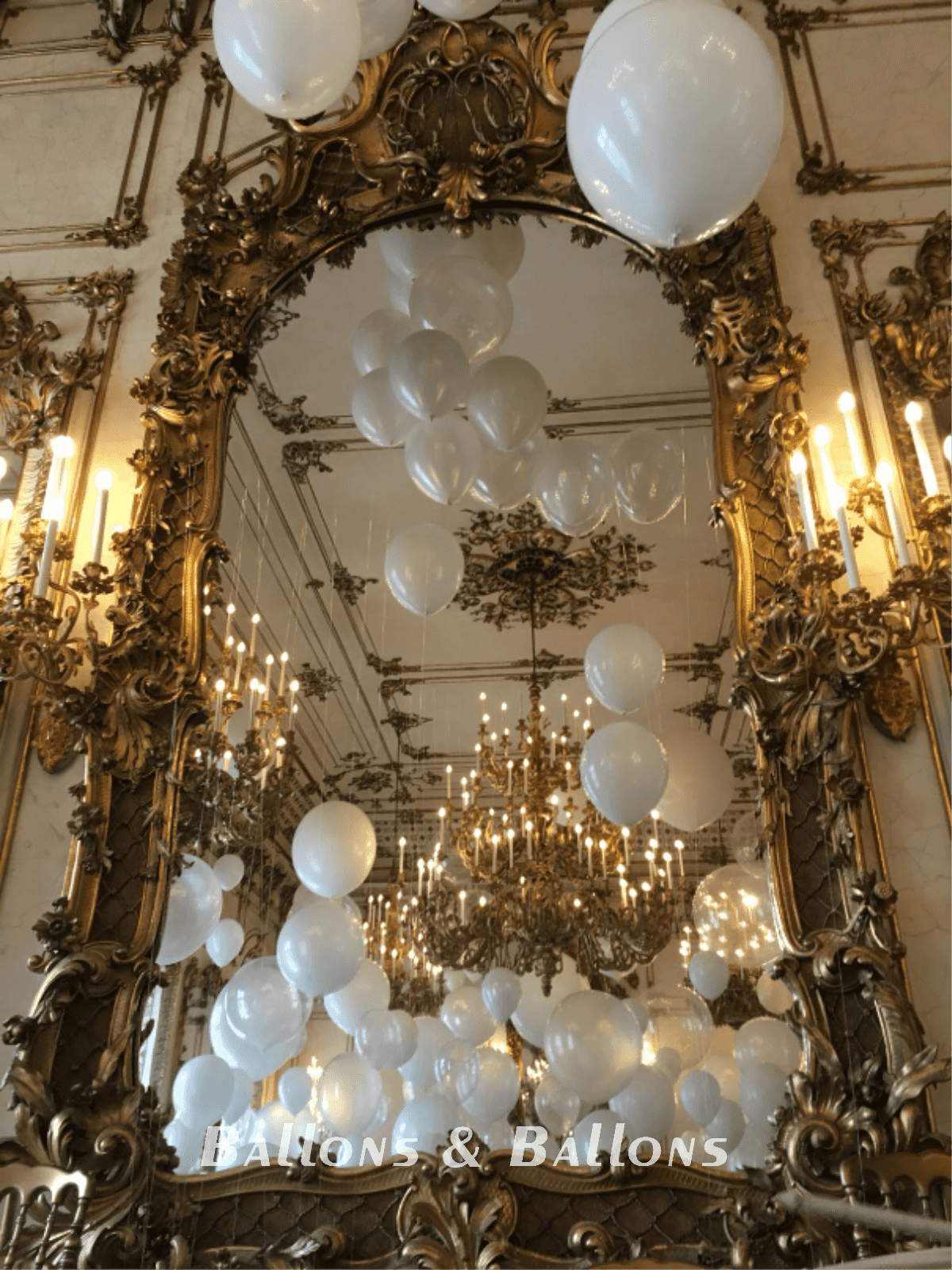 Ein Spiegel, der Luftballons in einem Lüster reflektiert.