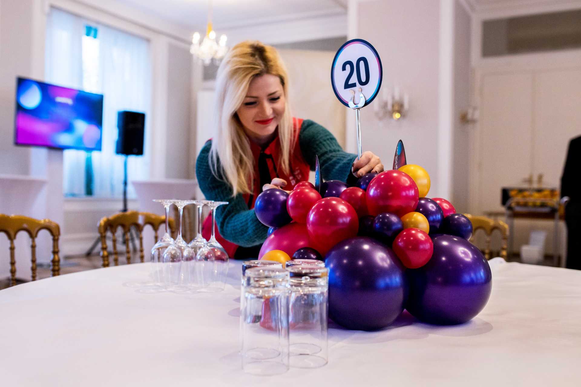 Frau dekoriert Tisch mit Ballons für eine Veranstaltung in Wien