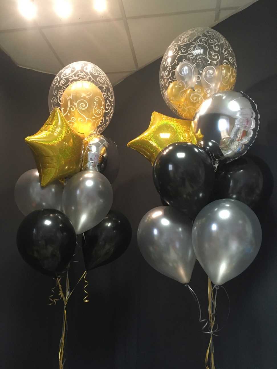 Zwei Ballons auf einem Tisch in Wien mit schwarzen, silbernen und goldenen Ballons
