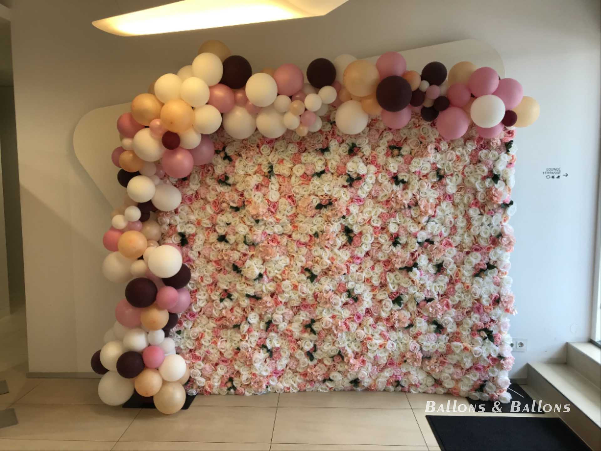 Eine Foto-Wand mit vielen Blumen, Ballons und Bändern