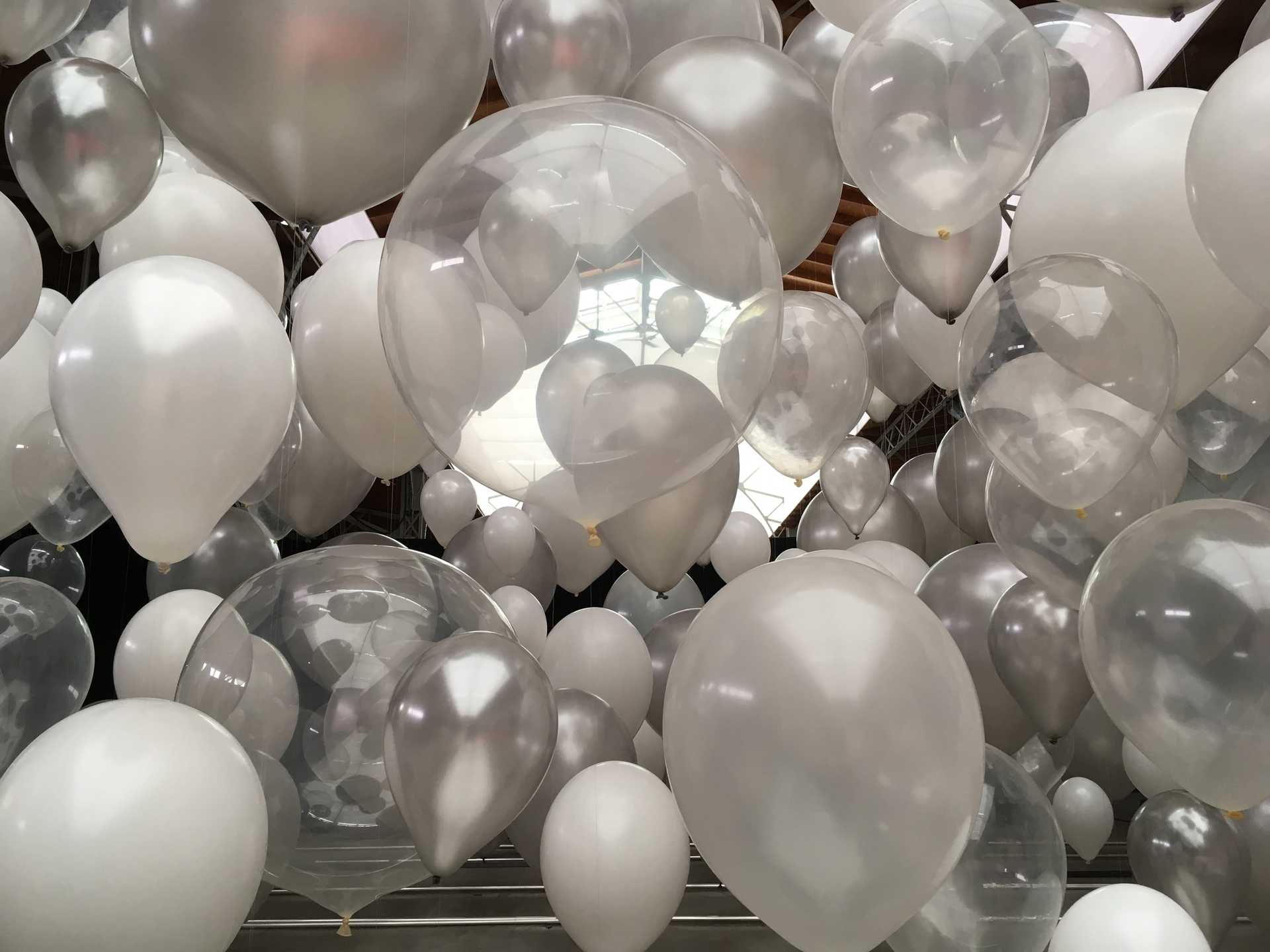Viele weiße und silberne Ballons hängen in der Luft in Wien.